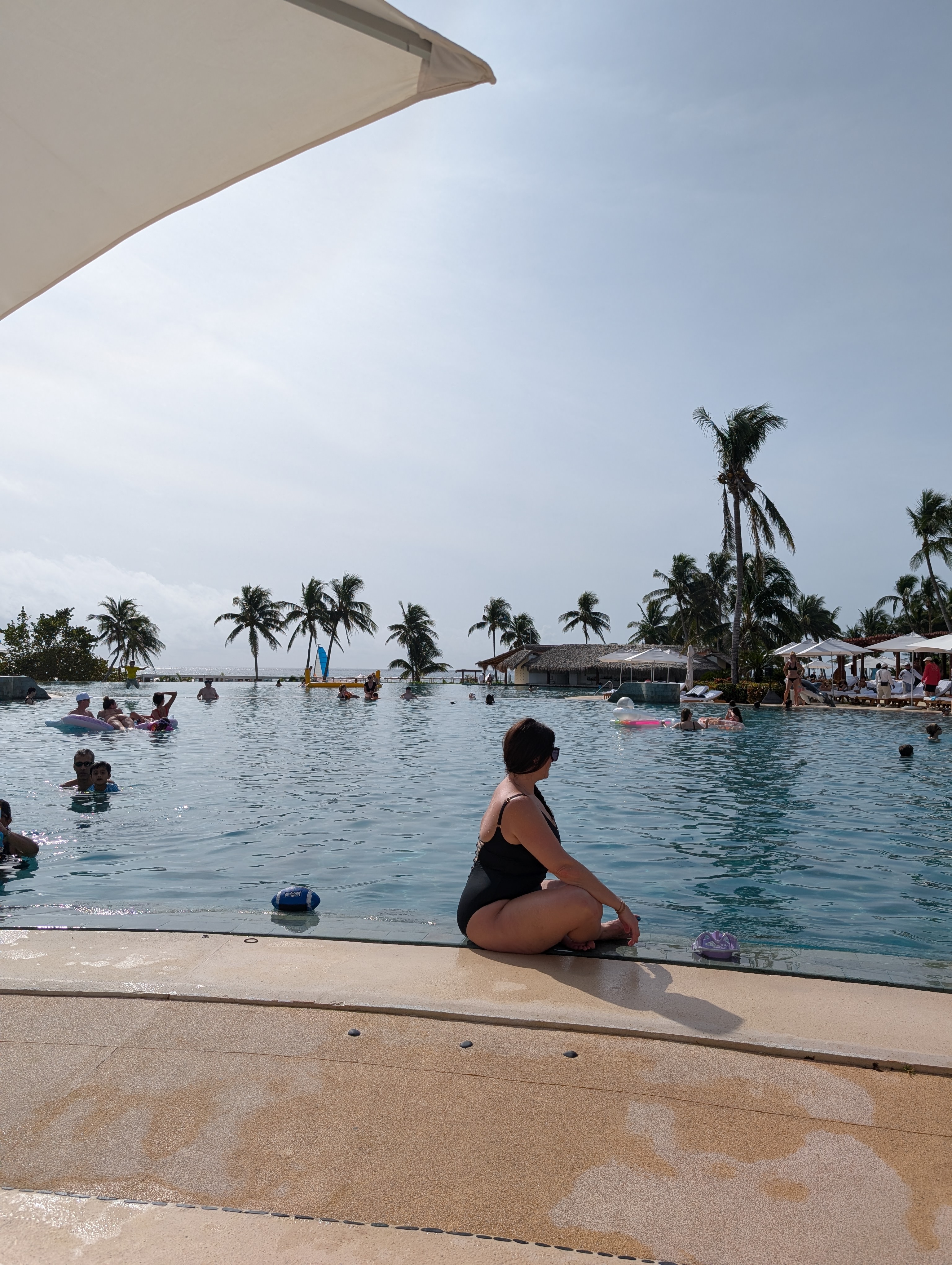 Grand Class pool at Grand Velas Riviera Maya with palm trees and Caribbean sky